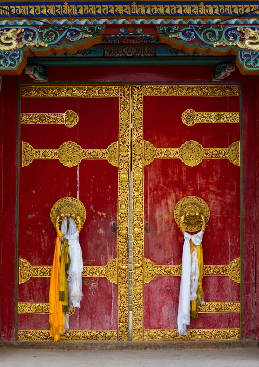 Ornate knockers on traditional buddhist door temple in Hezuo monastery, Gansu province, Hezuo, China