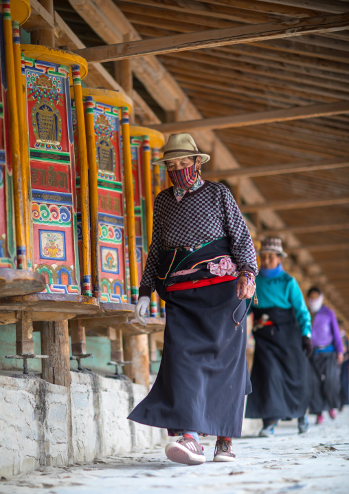 Tibetan pilgrims turning huge prayer wheels in Labrang monastery, Gansu province, Labrang, China
