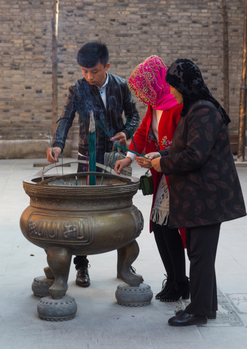 Hui muslim people burning incense stick in Yu Baba Gongbei shrine, Gansu province, Linxia, China