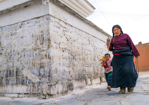 Tibetan nomad woman with her daughter holding a prayer wheel in her hand, Gansu province, Labrang, China