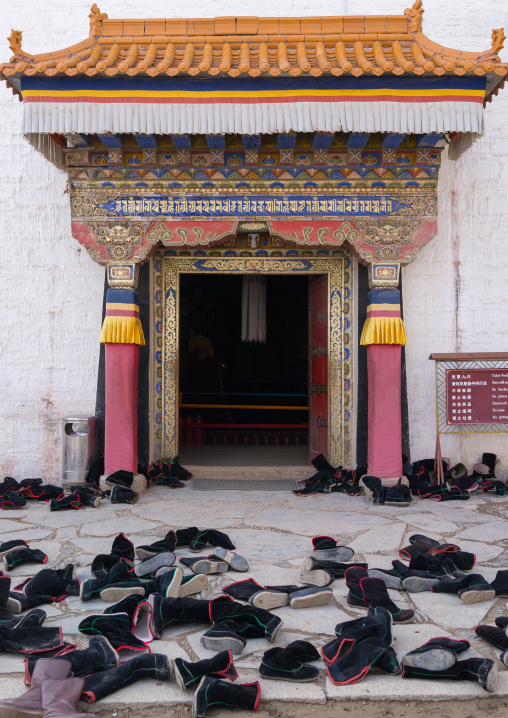 Tibetan monks boots in front of the entrance of a temple in Labrang monastery, Gansu province, Labrang, China
