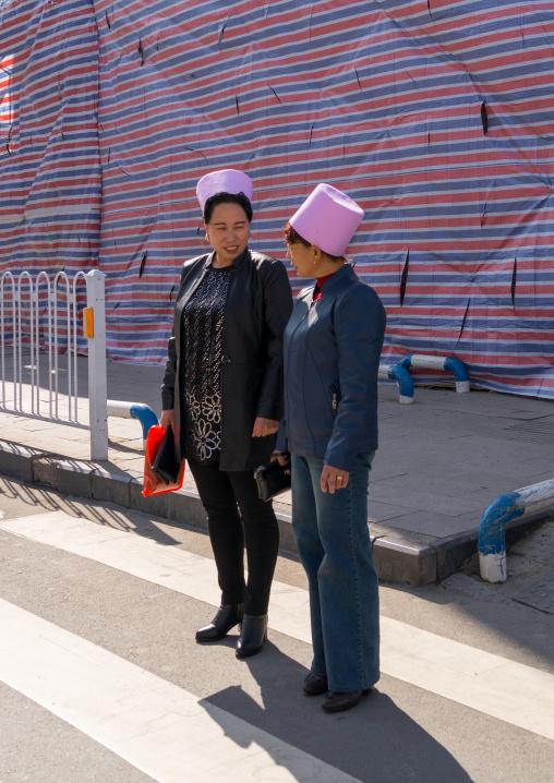 Muslim women with the traditional pink hats in the street, Gansu province, Linxia, China