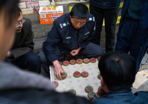 Group of people playing xiangqi chinese chess in the street, Gansu province, Lanzhou, China