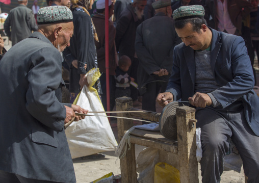 Uyghur Men Sharpening A Knife, Opal Village Market, Xinjiang Uyghur Autonomous Region, China