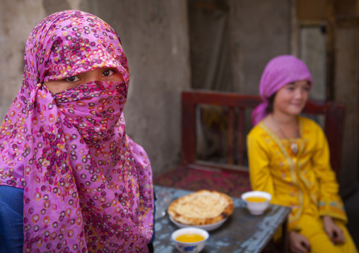 Uyghur Girls Drinking Safran Tea And Eating Bread In The Street, Keriya, Xinjiang Uyghur Autonomous Region, China