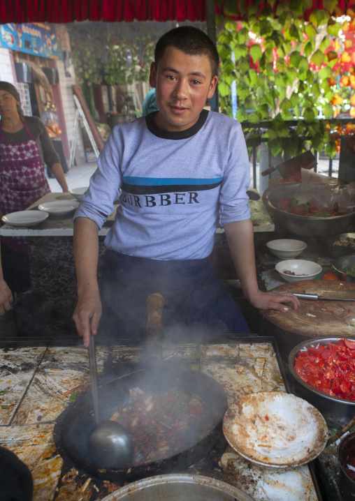 Young Man Cooking In Serik Buya Market, Yarkand, Xinjiang Uyghur Autonomous Region, China
