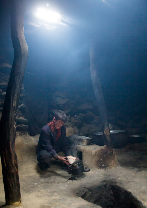 Wakhi teenage boy preparing salty milk tea inside his house, Big pamir, Wakhan, Afghanistan