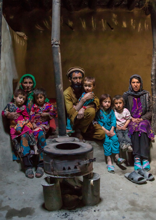 Afghan family in front of a stove, Badakhshan province, Khandood, Afghanistan