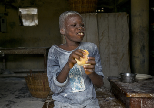 Benin, West Africa, Porto-Novo, boy working in a mill with his face coverded with flour