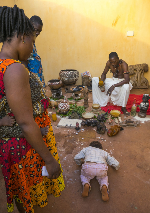 Benin, West Africa, Bonhicon, a child bowing in front of kagbanon bebe voodoo priest during a ceremony