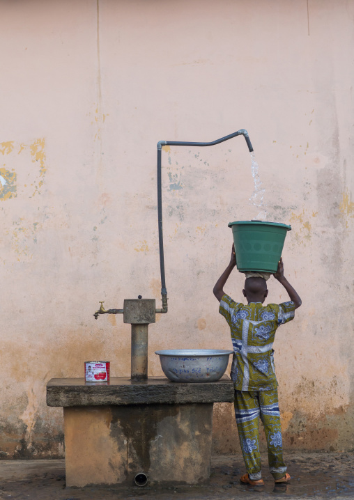 Benin, West Africa, Porto-Novo, child collecting water in the street