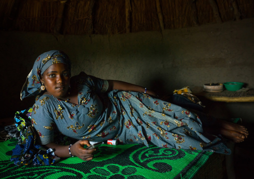 Benin, West Africa, Taneka-Koko, fulani peul bride waiting for her groom lying on her bed inside her hut