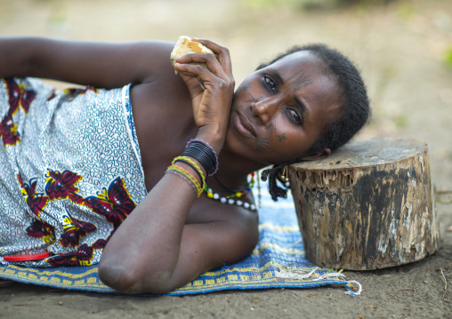 Benin, West Africa, Gossoue, a beautiful tattooed fulani peul tribe woman resting on a piece of wood