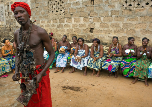 Benin, West Africa, Bopa, voodoo adept with a red scarf in front of a row of women during a ceremony