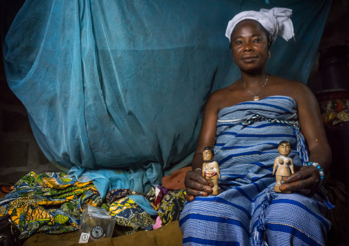 Benin, West Africa, Bopa, miss hounyoga with the carved wooden figures of her dead twins zinsou the boy and zinhoue the girl
