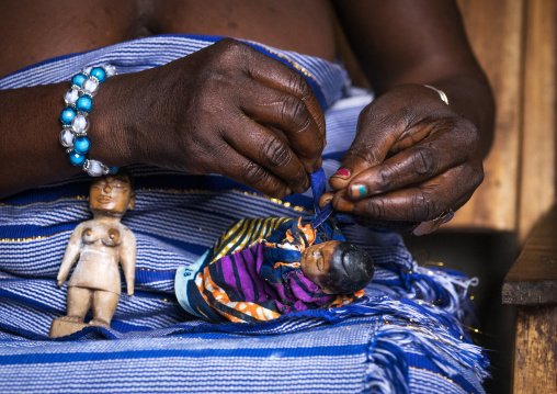 Benin, West Africa, Bopa, miss hounyoga dressing the carved wooden figures of her dead twins