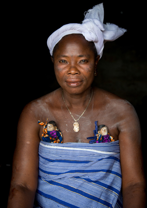 Benin, West Africa, Bopa, miss hounyoga carrying the carved wooden figures made to house the soul of her dead twins