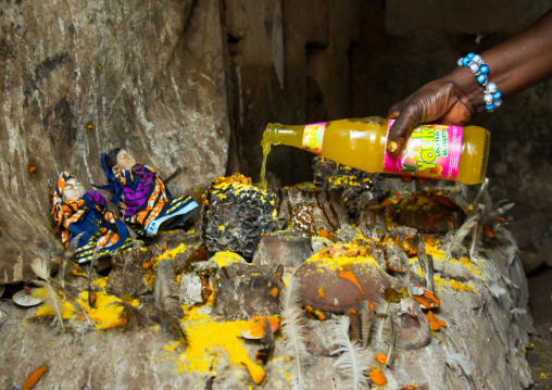 Benin, West Africa, Bopa, miss hounyoga putting fruit juice offerings to the deity dan for the voodoo dead twins cult