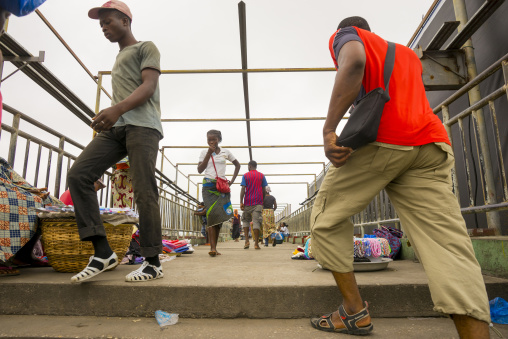 Benin, West Africa, Cotonou, people crossing the bridge over dantokpa market