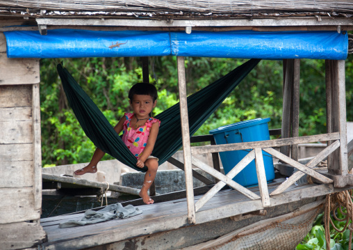 Cambodian girl on a hammock in the floating village on Tonle Sap lake, Siem Reap Province, Chong Kneas, Cambodia