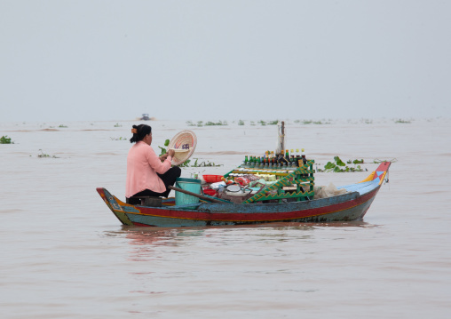 Woman selling food on boat in the floating village on Tonle Sap lake, Siem Reap Province, Chong Kneas, Cambodia