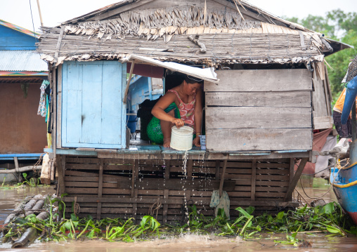 Cambodian woman standing at the door of her house in the floating village on Tonle Sap lake, Siem Reap Province, Chong Kneas, Cambodia