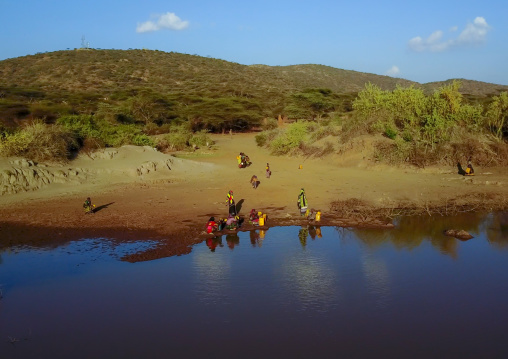 Aerial view of Borana tribe people filling jerricans in a water reservoir used for animals, Oromia, Yabelo, Ethiopia