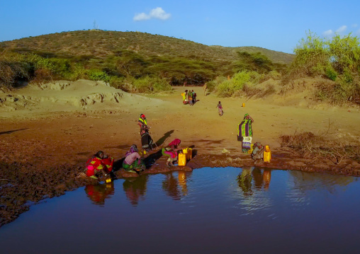 Aerial view of Borana tribe people filling jerricans in a water reservoir used for animals, Oromia, Yabelo, Ethiopia