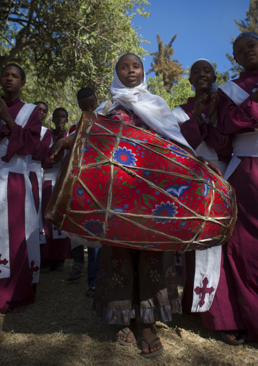 Girl playing drum during an Ethiopian wedding in an orthodox church, Zway, Ethiopia