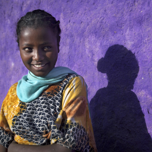 Portrait Of A Young Woman With Toothy Smile, Near A Purple Painted Wall, Harar, Ethiopia