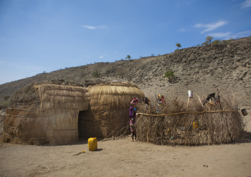 Karrayu Tribe Mother And Her Two Kids Behind The Wooden Fence Of Their House Down A Rocky Hill, Metahara, Ethiopia