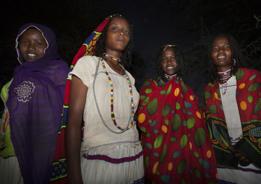 Night Shot Of Four Karrayyu Tribe Girls With Stranded Hair In Colourful Traditional Clothes During Gadaaa Ceremony, Metahara, Ethiopia