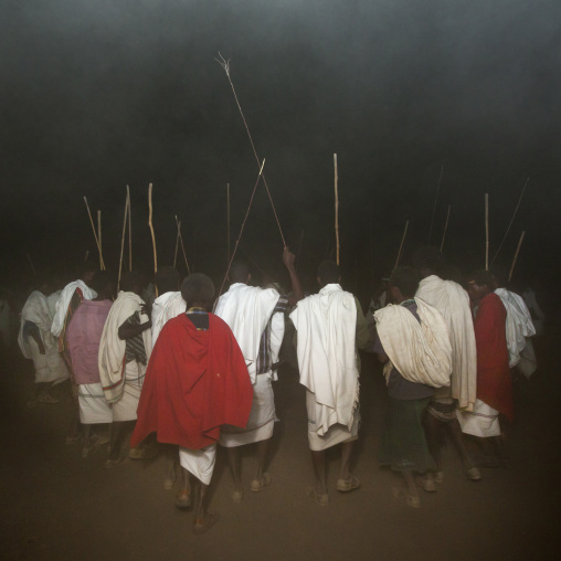 Rear View Of A Group Of Karrayyu Tribe Men In A Cloud Of Dust During Gadaaa Ceremony, Metahara, Ethiopia