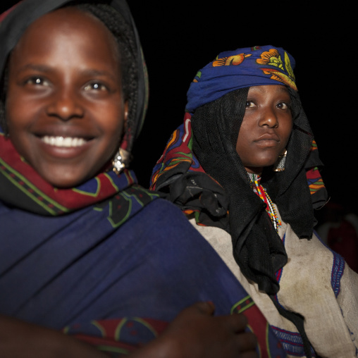 Night Shot Of Two Karrayyu Tribe Girls With Toothy Smile During Gadaaa Ceremony, Metahara, Ethiopia