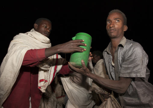 Night Shot Of A Karrayyu Tribe Man Bringing Food To Another Karrayyu Family During Gadaaa Ceremony, Metahara, Ethiopia