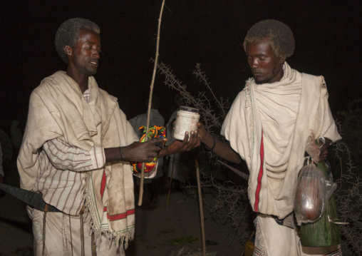 Night Shot Of A Karrayyu Tribe Man Bringing Food To Another Karrayyu Family During Gadaaa Ceremony, Metahara, Ethiopia