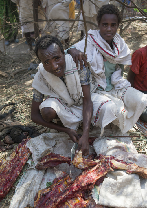 Four Karrayyu Tribe Men Cutting Meat For The Gadaaa Ceremony, Metahara, Ethiopia