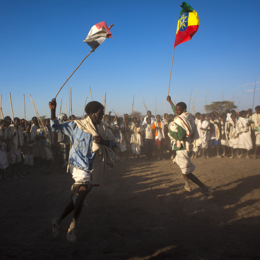 Karrayyu Tribe Men Carrying The Oromo And Ethiopian Flag Flag During Choreographed Stick Fighting Dance, Gadaaa Ceremony, Metahara, Ethiopia