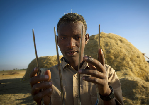 Portrait of a young man holding a pitch fork for harvest, Adama, Ethiopia