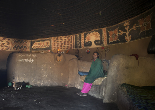Portrait of an old woman sitting on her bed inside her tukul house, Alaba, Ethiopia