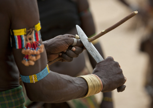Whipper Cutting His Wooden Whip Before Celebrating Bull Jumping Ceremony, Omo Valley, Ethiopia