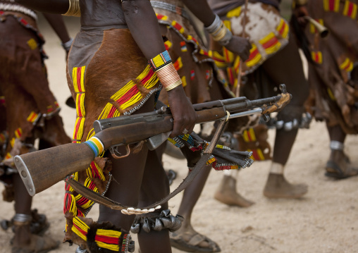 Hamer Tribe Woman Walking With  Rifle In Hand During Bull Leaping Ceremony, Omo Valley, Ethiopia