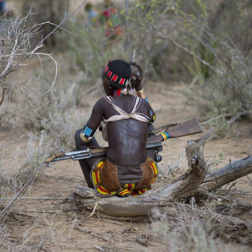View From The Whipped Back Of A Hamer Tribe Woman Holding A Rifle During Bull Leaping Ceremony, Omo Valley, Ethiopia