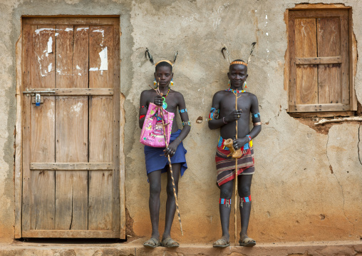 Two Traditionally Dressed Banna Teenage Boys Outside A House With Feather Headgear Omo Valley Ethiopia