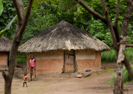 Concrete house with thatch roof  ari mother and girl omo valley Ethiopia