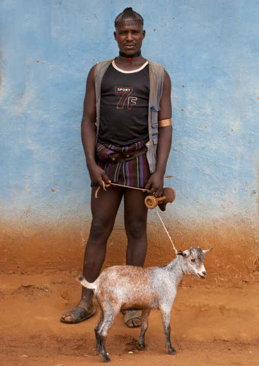 Tsemay tribe man posing with his goat in key afer, Omo valley, Ethiopia