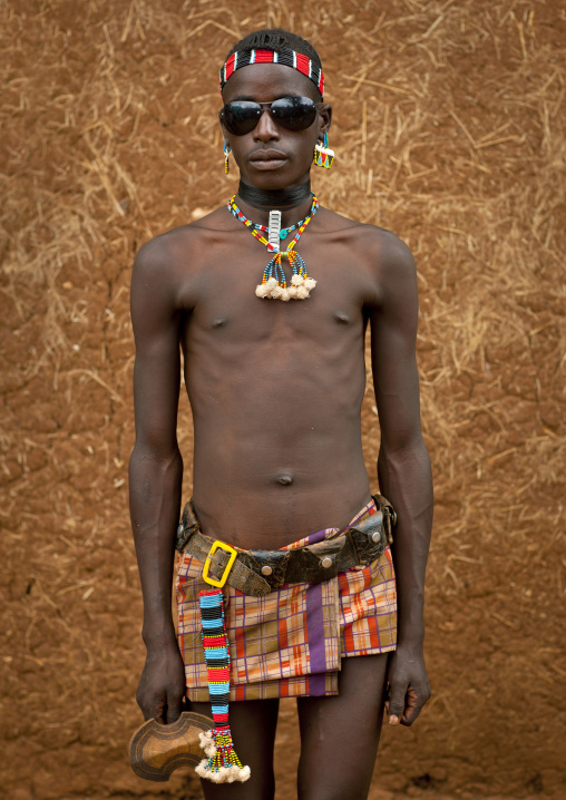 Fashionable tsemay tribe man posing with sunglasses in key afer, Omo valley, Ethiopia