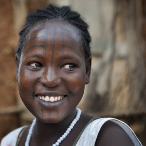Tattooed face of a smiling tsemay woman at key afer market, Omo valley, Ethiopia