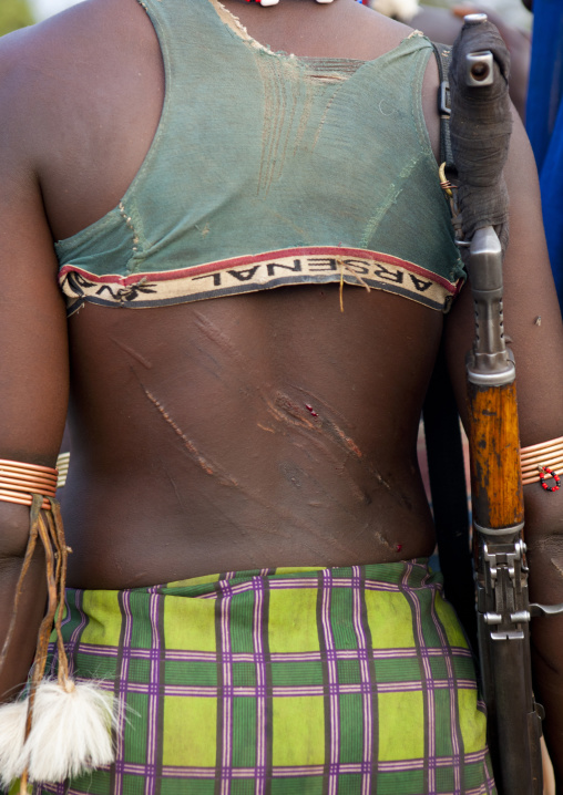 Back Of Banna Woman Previously Flogged Carrying Kalashnikov Rifle  Bull Jumping Ceremony Omo Valley  Ethiopia