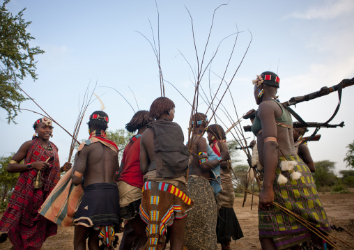 Women Walking With Whips And Kalashnikov Rifles At  Bull Jumping Ceremony Ethiopia